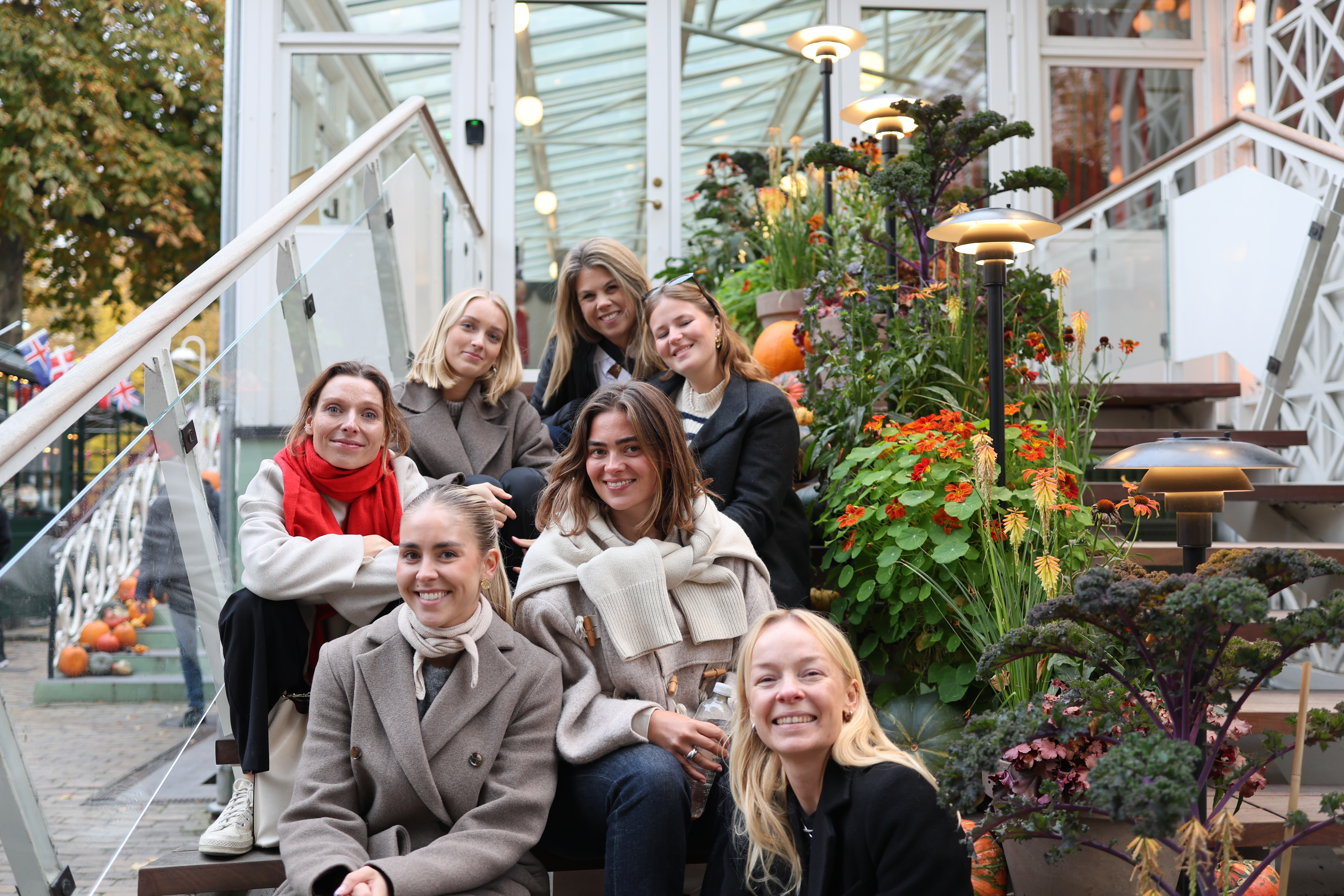 Women sitting on a bench smiling in winter clothes.
