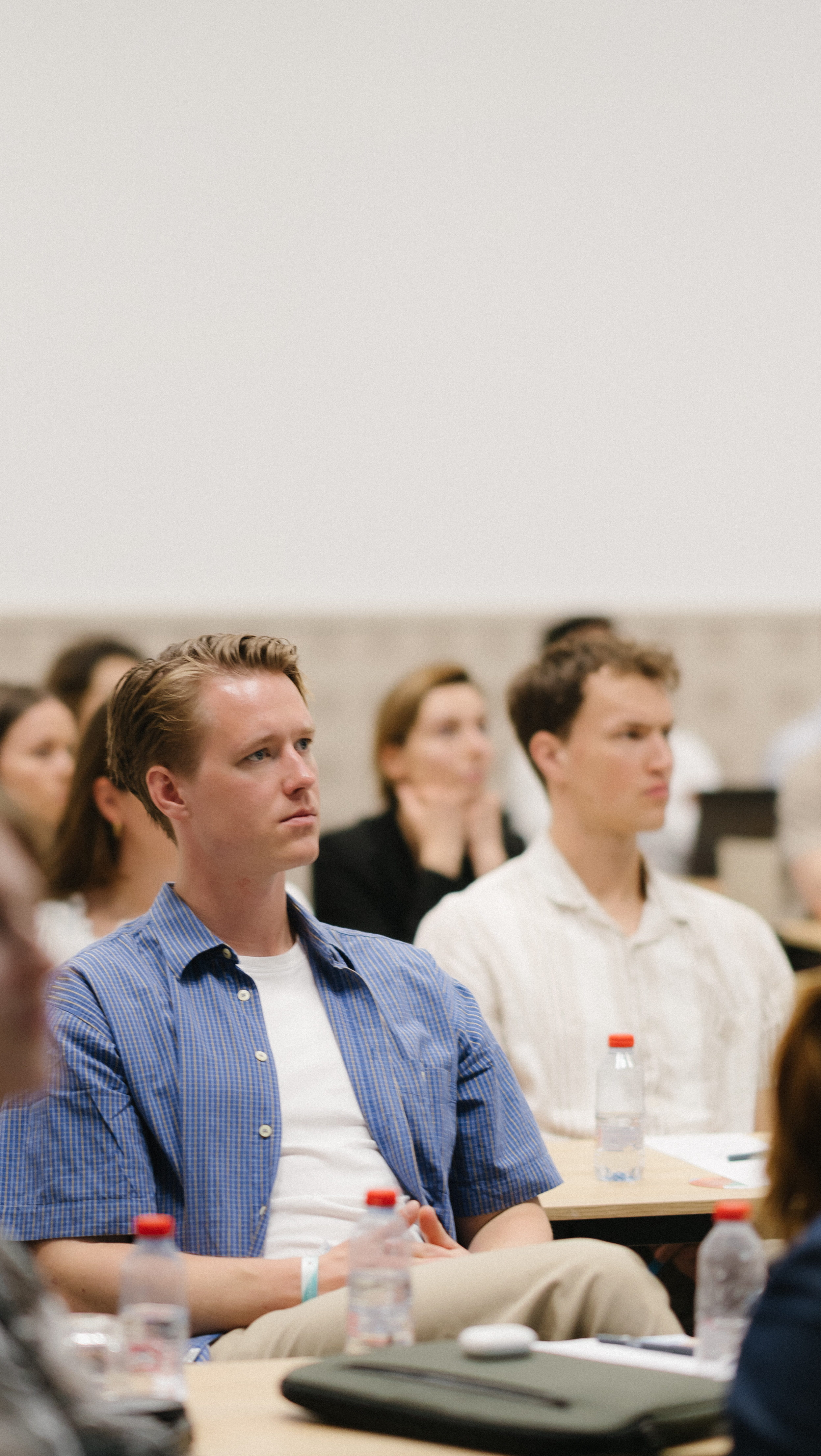 Man focusing in a business event in a blue shirt.