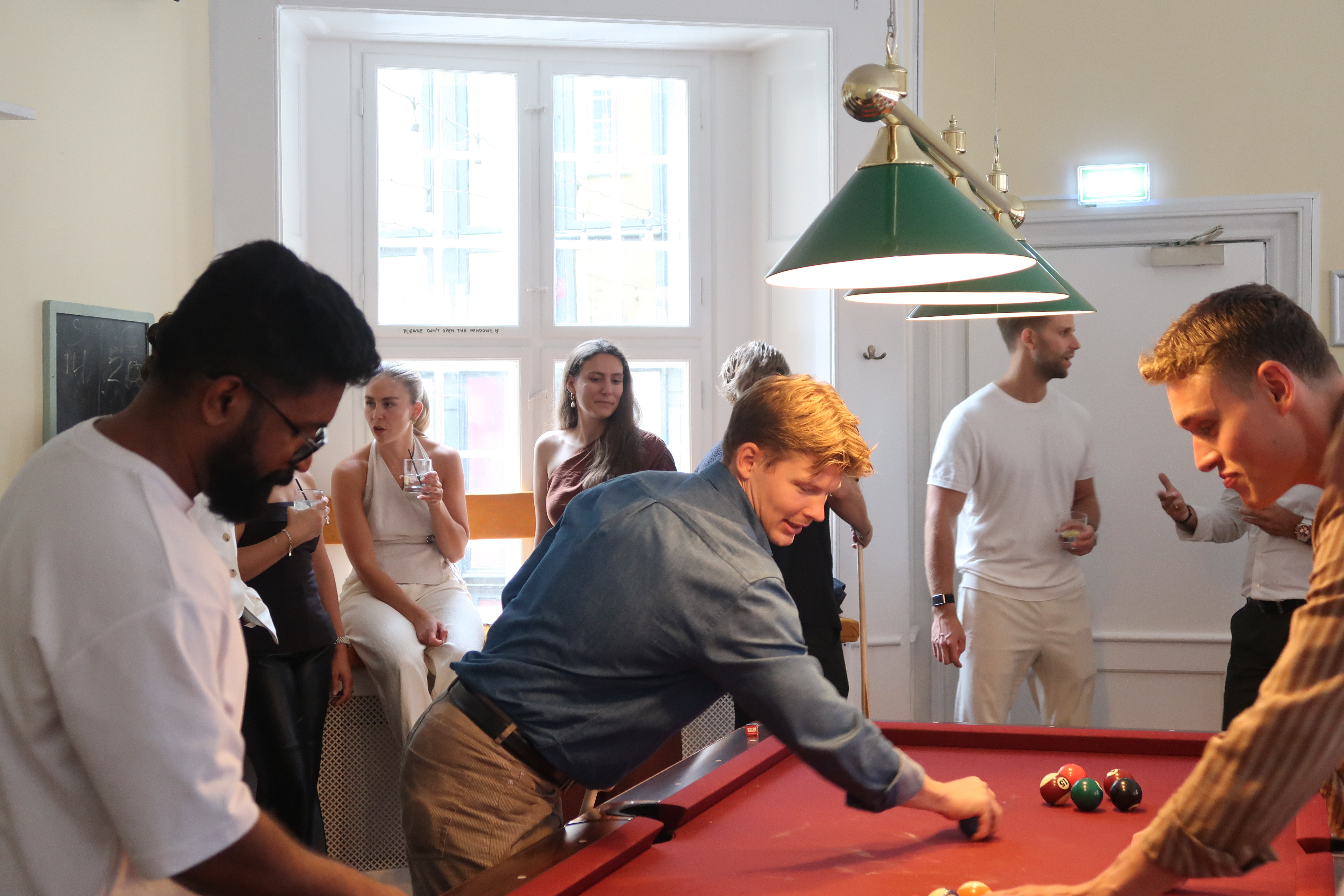 Man playing pool with other people.