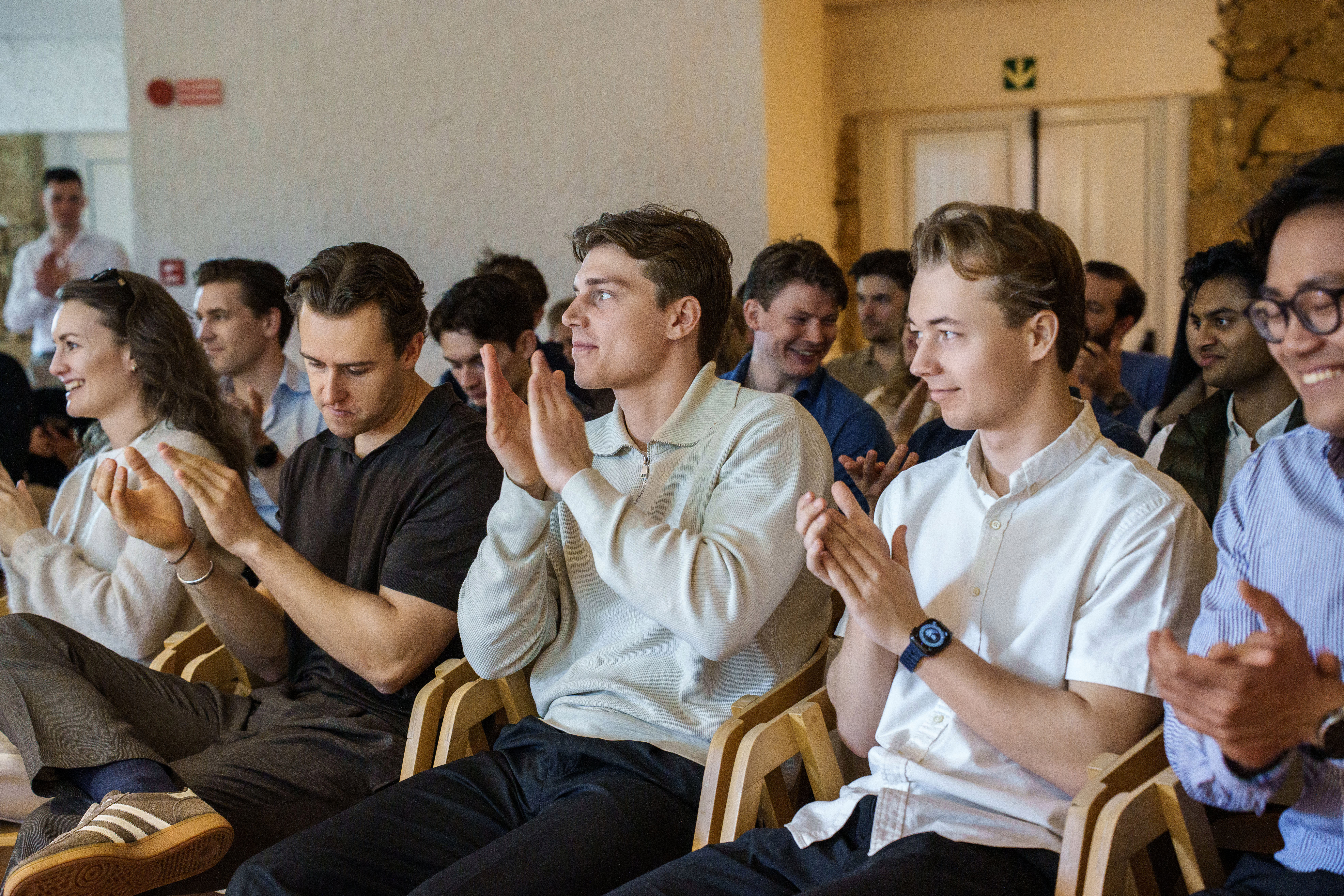 Two men clapping at a business event.