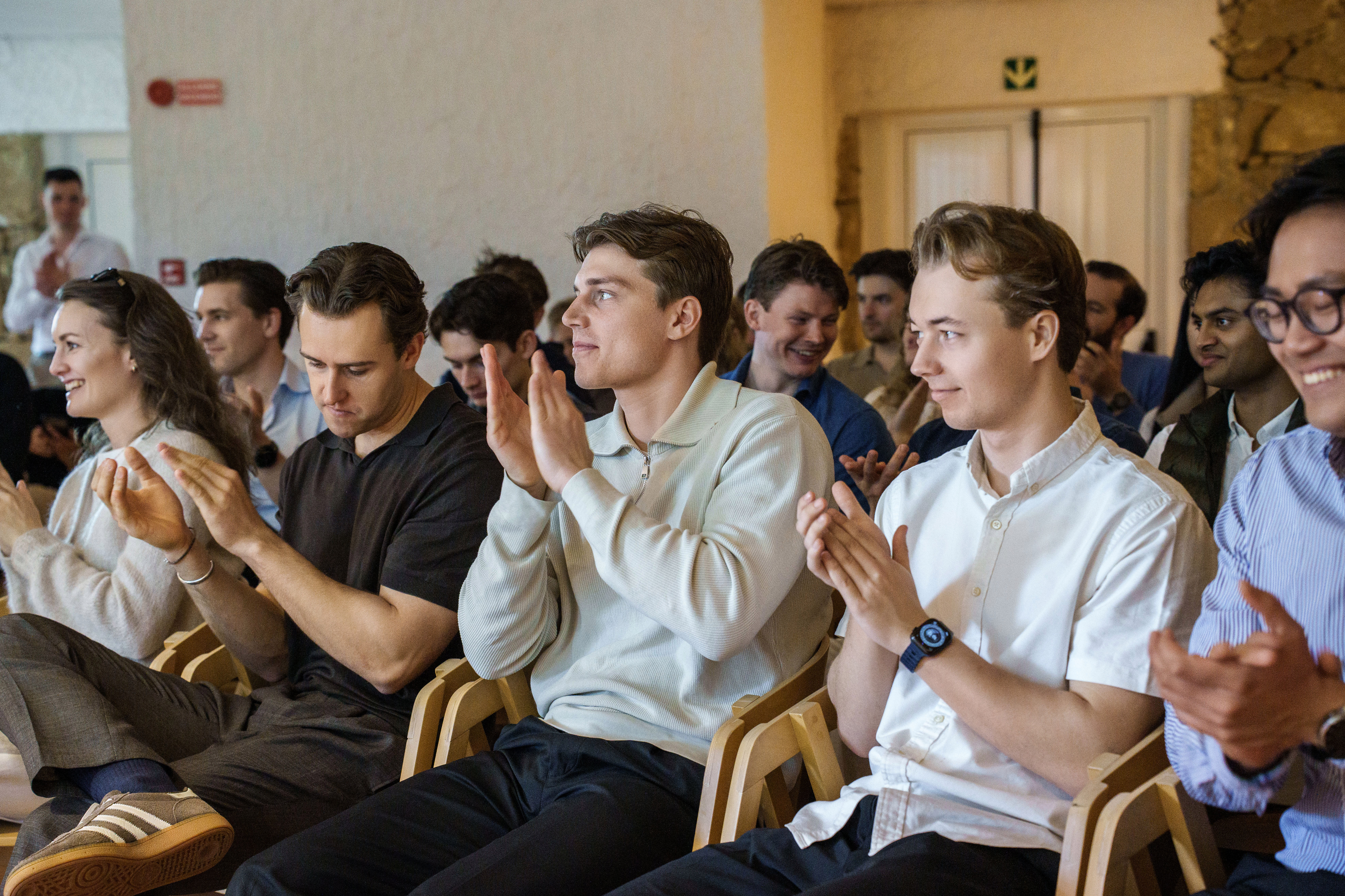 Two men clapping at a business event.