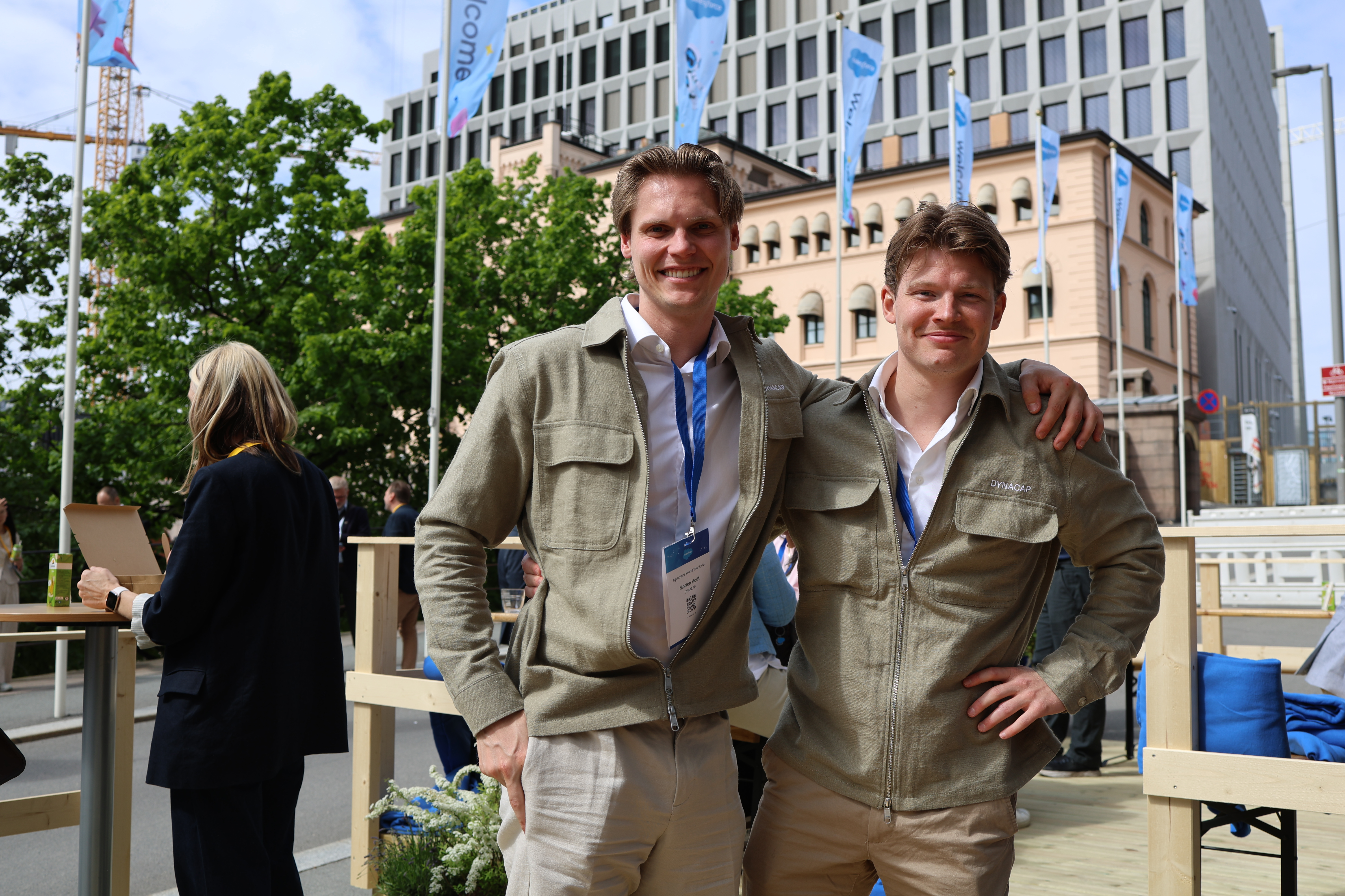 Two men in green overshirts smiling at a business event