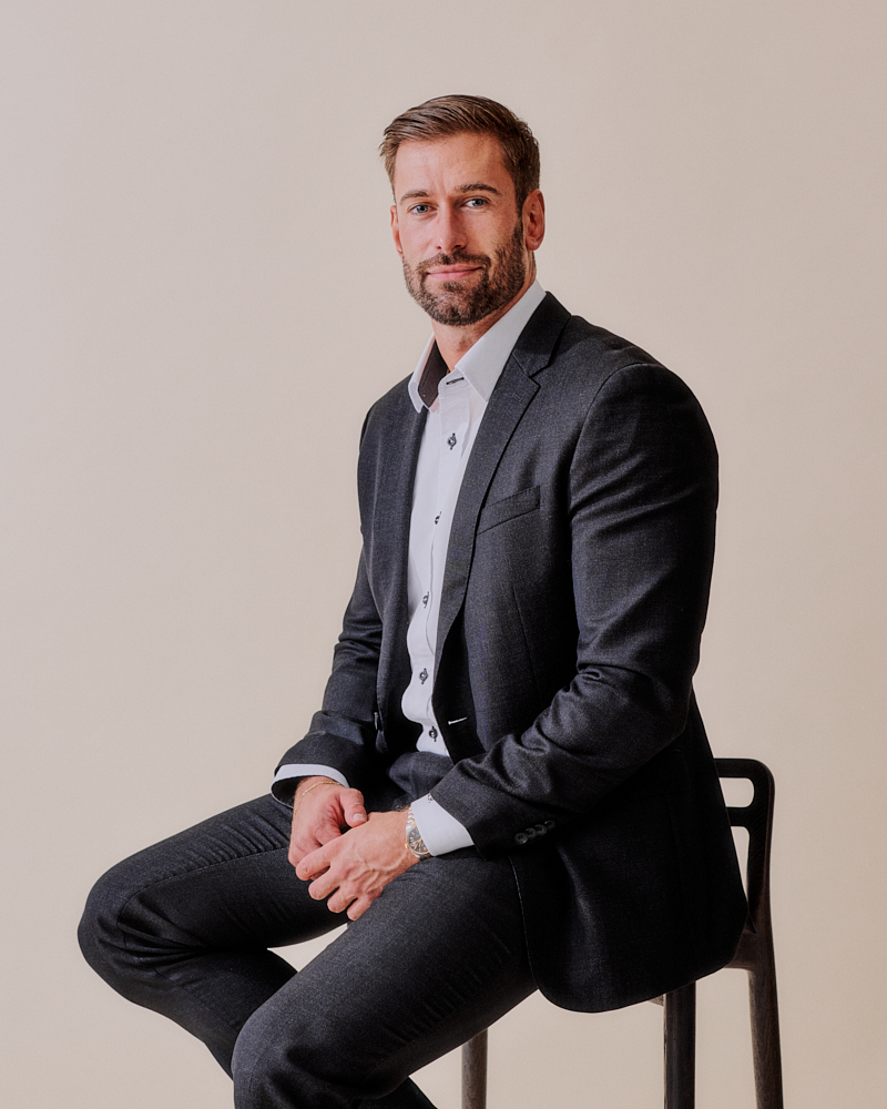 A man sitting on a chair in a suit