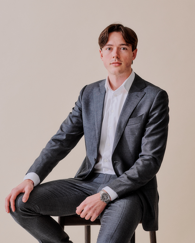 A man sitting on a chair in a suit